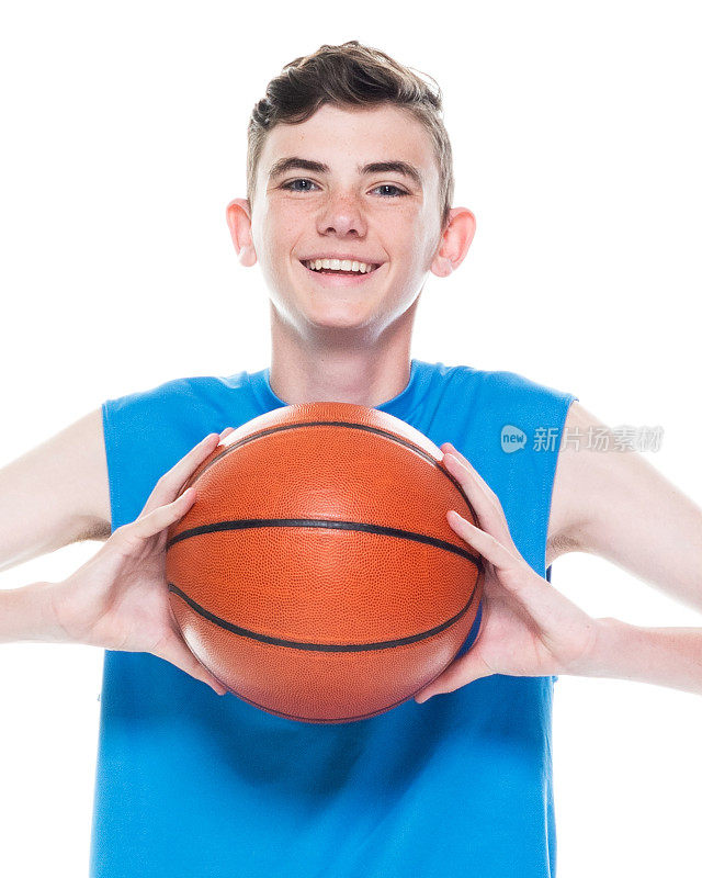 正面视图/一人/一人/一个十几岁的男孩/腰以上的12-13岁英俊的人白人男性/年轻男子篮球运动员/男孩/十几岁的男孩站在白人背景和拿着篮球
